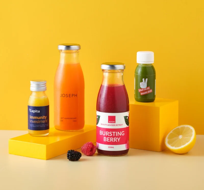 Bottles of different sizes with juice and smoothies on a yellow background